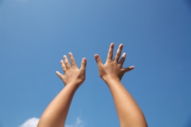 両手を空にかざすイメージ